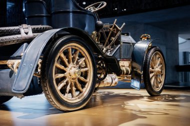 Ön taraftaki fotoğraf. İki koltuklu ve yüksek direksiyonlu gösterişli eski bir araba..