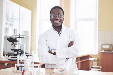 Afrikalı Amerikalı bir işçi laboratuarda deneyler yapıyor.