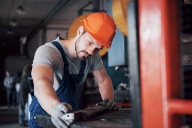 Başlık takmış deneyimli bir operatör. Metal endüstrisi konsepti profesyonel mühendis metal işçisi imalat atölyesinde Cnc değirmen makine merkezi işletiyor.
