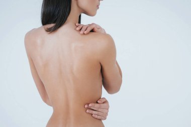 Ellerini cesedin üstünde tut. Genç esmer kız beyaz arka planda çıplak kalırken kameraya arkasını dönüyor..