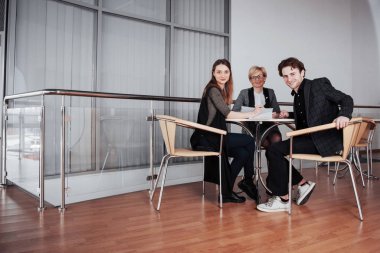 İş, teknoloji ve ofis kavramı - gülümseyen bayan patron iş ekibiyle konuşuyor.