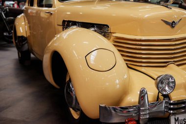 Sinsheim, Almanya - 16 Ekim 2018: Technik Müzesi. Fotoğrafı kapat. Arka planda motosikletli, krem renkli, eski model bir aracın sağ ve ön kısmı..