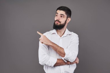 Yönünü gösteren ve parmağıyla işaret eden neşeli yakışıklı bir adam. Şuraya bak.