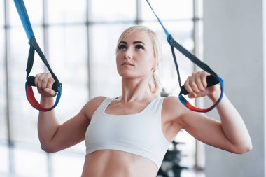 İtme yapıyor kadınlar trx fitness askıları kavramı egzersiz sağlıklı yaşam spor salonunda silahlarla eğitim ups.