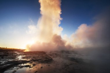 İzlanda'daki fantastik günbatımı Strokkur şofben erüpsiyon. Harika renkler.
