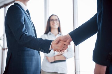 Ofisteki toplantıda el sıkışan iki kendine güvenen iş adamı, selamlaşma ve ortaklık kavramı.