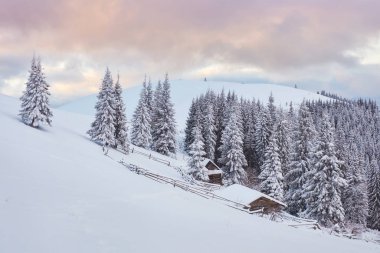 Majestic sunset at small village on a snowy hill under Ukrainian. Villages in the mountains in winter. Beautiful winter landscape. Carpathians, Ukraine, Europe. clipart