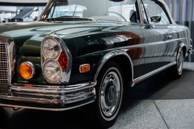 Zemin katta yakalandı. Kapalı alanda duran muhteşem yeşil renkli arabanın önünden fotoğraf..