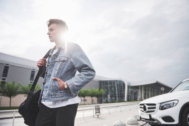 Havaalanında genç ve güzel bir adam uçağı bekliyor.