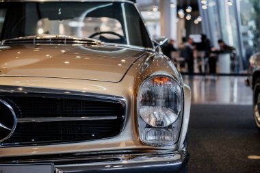 Stuttgart, Almanya - 16 Ekim 2018: Mercedes Müzesi. Kahverengi otomobilin kesilmiş fotoğrafı. İnsanlar arkada konuşuyor..