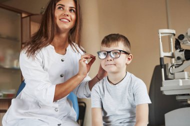 Şimdi şu harflerle dolu tahtaya bak. Çocuk doktor ofisinde oturuyor ve yeni mavi gözlükler deniyor..