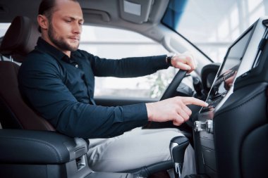 Araba süren genç bir adamın yakın görüntüsü. Bir iş gezisi başlat. Test sürüşü yeni bir otomatik.