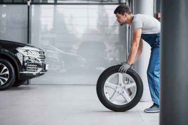Tamirhanede lastik tutan bir tamirci. Kış ve yaz lastiklerinin yerine.