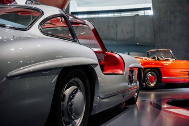 Arka planda kırmızı bir otomobille park yerinde kapıları açık olan harika beyaz tahsilat arabası..