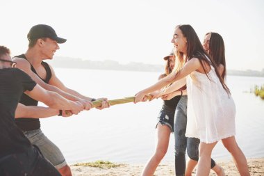 Kumlu bir plajda oynayan komik arkadaşlar. Mutlu, dost canlısı arkadaşlar dışarıda eğlencelidir..