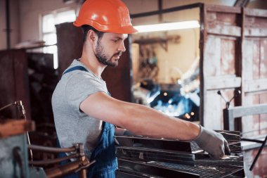 Başlık takmış deneyimli bir operatör. Metal endüstrisi konsepti profesyonel mühendis metal işçisi imalat atölyesinde Cnc değirmen makine merkezi işletiyor.