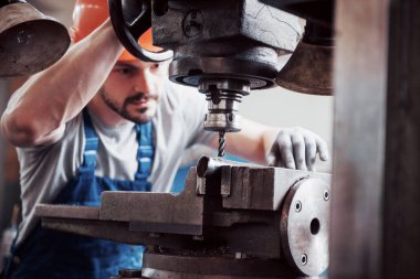 Başlık takmış deneyimli bir operatör. Metal endüstrisi konsepti profesyonel mühendis metal işçisi imalat atölyesinde Cnc değirmen makine merkezi işletiyor.