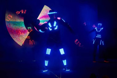 Laser show performance, dancers in led suits with LED lamp, very beautiful night club performance, party.