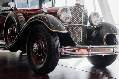 Stuttgart, Almanya - 16 Ekim 2018: Mercedes Müzesi. Yan tarafında yedek tekerlek olan eski tarz kırmızı uzun bir araba. Pencereler ve gün ışığı.