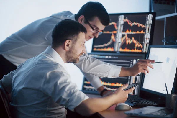 Team Von Börsenmaklern Unterhalten Sich Einem Dunklen Büro Mit Bildschirmen — Stockfoto