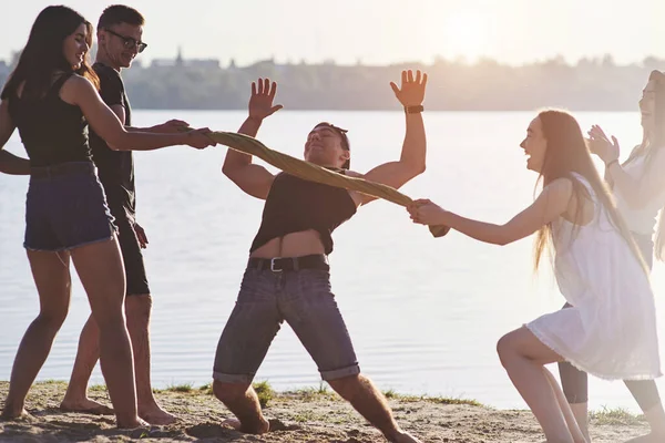 Mutlu arkadaşlar sahilde eğlenir - yaz tatilinde genç insanlar.