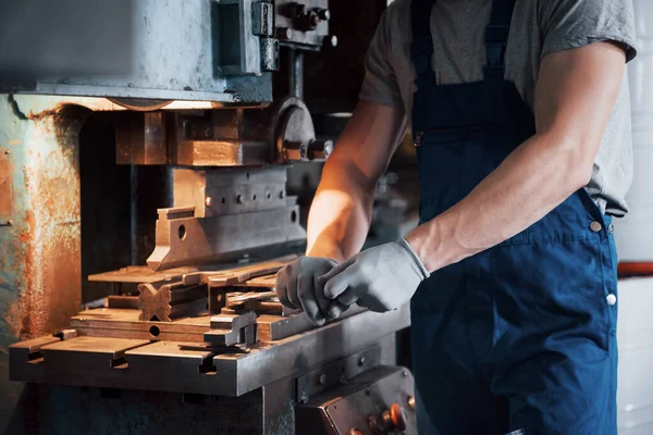 Portrait of a young worker in a hard hat at a large metalworking plant. The engineer serves the machines and manufactures parts for gas equipment.