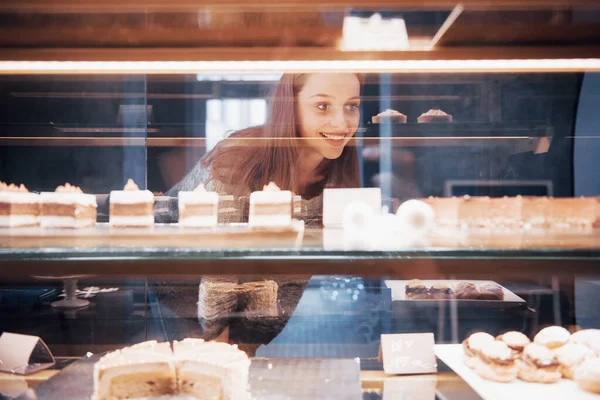 Mujer Sonriente Cámara Través Vitrina Con Dulces Pasteles Interior Cafetería — Foto de Stock