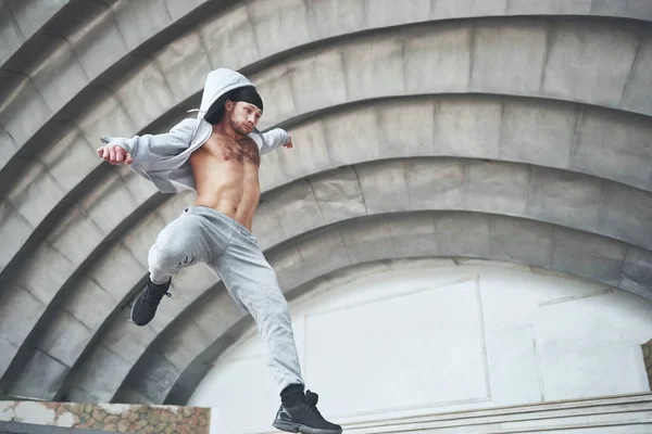 Man engaged in parkour jumping on the street workout
