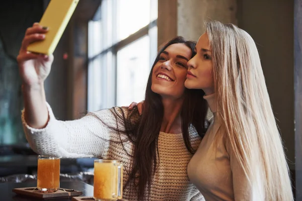 Genç Bayan Arkadaşlar Restoranda Iki Sarı Içecekle Selfie Çekiyorlar — Stok fotoğraf