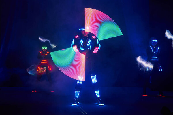 Laser show performance, dancers in led suits with LED lamp, very beautiful night club performance, party.