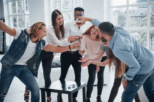 Χαρούμενοι Νεαροί Φίλοι Διασκεδάζουν Και Πίνουν Στο Λευκό Εσωτερικό — Φωτογραφία Αρχείου
