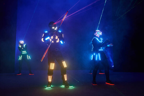 Laser show performance, dancers in led suits with LED lamp, very beautiful night club performance, party.