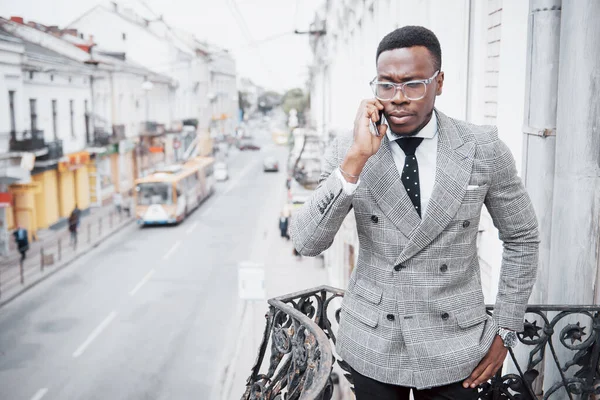 Mladý Afričan Formálním Oblečení Mluví Mobilním Telefonu Usmívá Zatímco Stojí — Stock fotografie