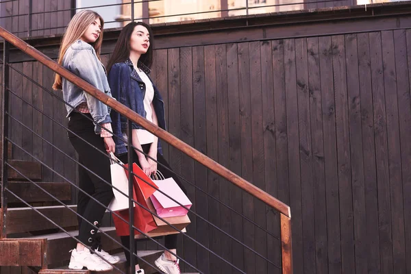 Two Young Woman Carrying Shopping Bags While Walking Stairs Visiting — ストック写真