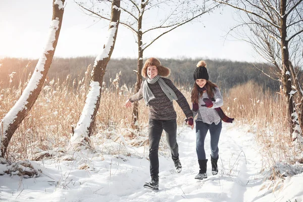 Couple has fun and laughs. kiss. Young hipster couple hugging each other in winter park. Winter love story, a beautiful stylish young couple. Winter fashion concept with boyfriend and girlfriend.