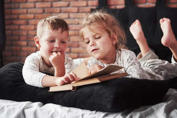 Zwei Kinder Liegen Auf Einem Großen Bett Und Lesen Ein — Stockfoto