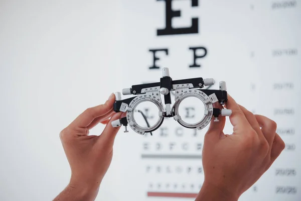 Phoropter Foto Vrouw Handen Houden Bril Achtergrond Van Oogkaart — Stockfoto