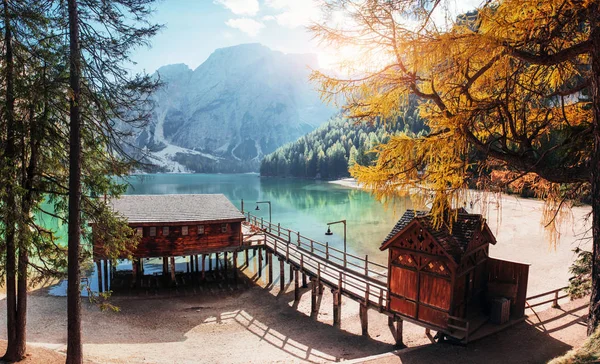 Lovely weather. Good landscape with mountains. Touristic place with wooden building and pear.