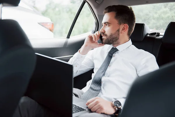 Giovane Uomo Affari Che Lavora Computer Portatile Parla Telefono Mentre — Foto Stock