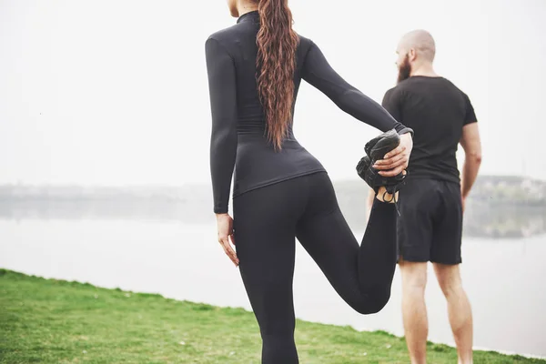 Fitnesspaar Dat Zich Buiten Het Park Bij Het Water Uitstrekt — Stockfoto