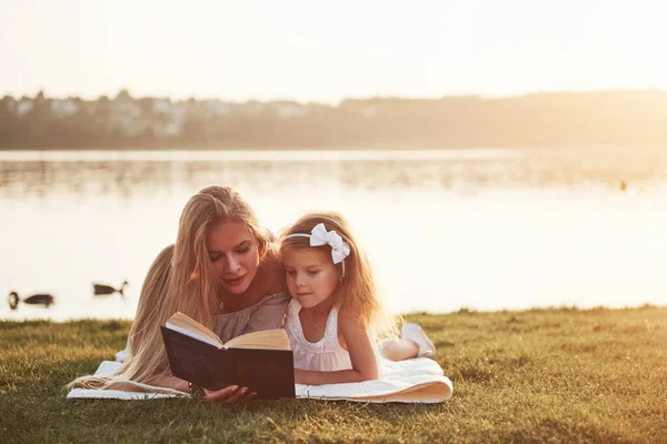 Madre Con Niño Lee Libro Sobre Hierba — Foto de Stock