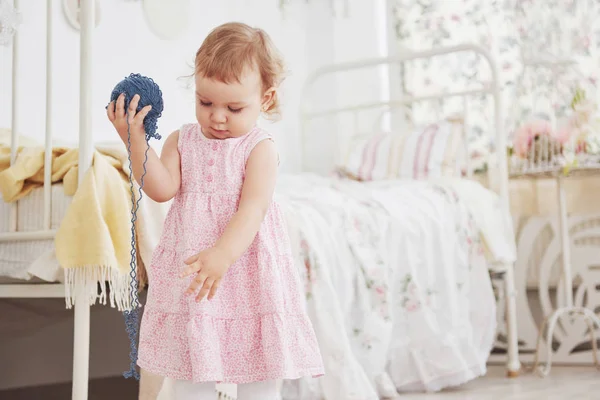 幼少期のコンセプト カラフルな糸で可愛いドレス遊びで赤ちゃんの女の子 白ヴィンテージ子供部屋 — ストック写真