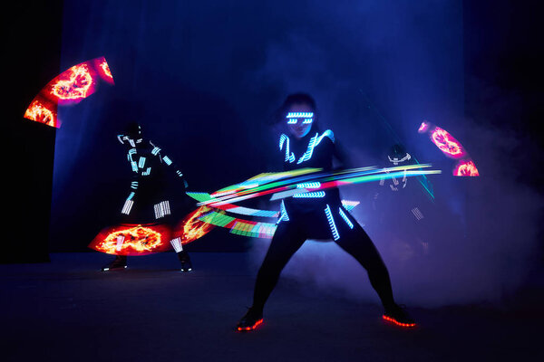 Laser show performance, dancers in led suits with LED lamp, very beautiful night club performance, party.