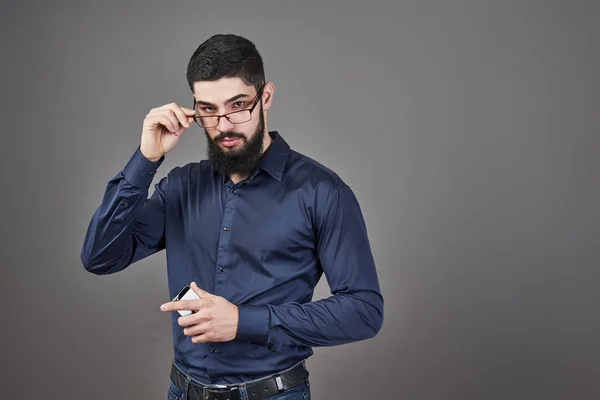 Homem Feliz Óculos Com Smartphone Mãos Fundo Cinza — Fotografia de Stock