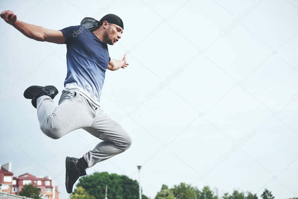 Young sports man doing parkour in the city