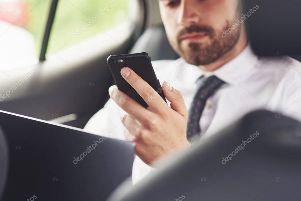 Man is a man working on a laptop and testing on mobile devices