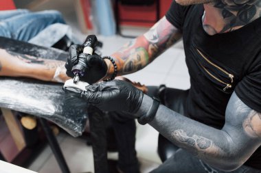 Dövme makinesini kapat. Siyah steril eldivenler ustası. Kuaförde resim yapıyor..