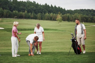 Golf sahasındaki bir grup şık arkadaş yeni bir oyun öğreniyor..