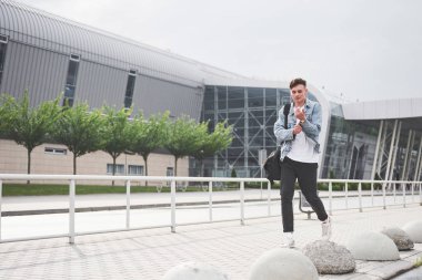 Havaalanında genç ve güzel bir adam uçağı bekliyor.