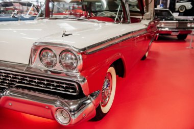 Sinsheim, Almanya - 16 Ekim 2018: Technik Müzesi. Arkadaki diğer araçlar. Araba fuarındaki kırmızı fayansın üzerine park etmiş eski moda beyaz bir araba..